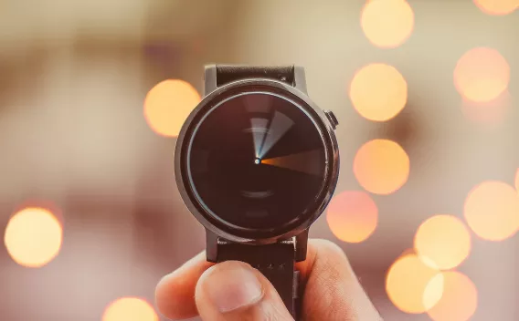 Hand holding a watch with the hands blurred